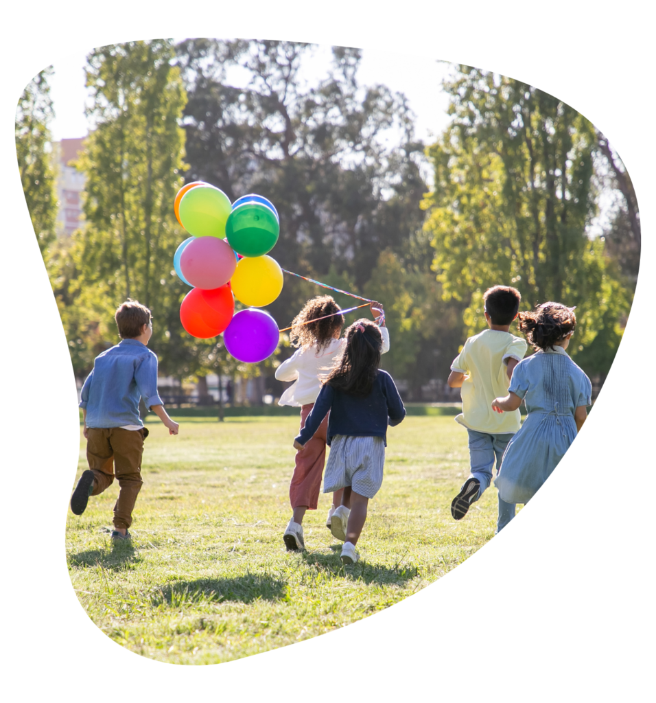 Kinder laufen gemeinsam mit bunten Luftballons über eine sonnige Wiese